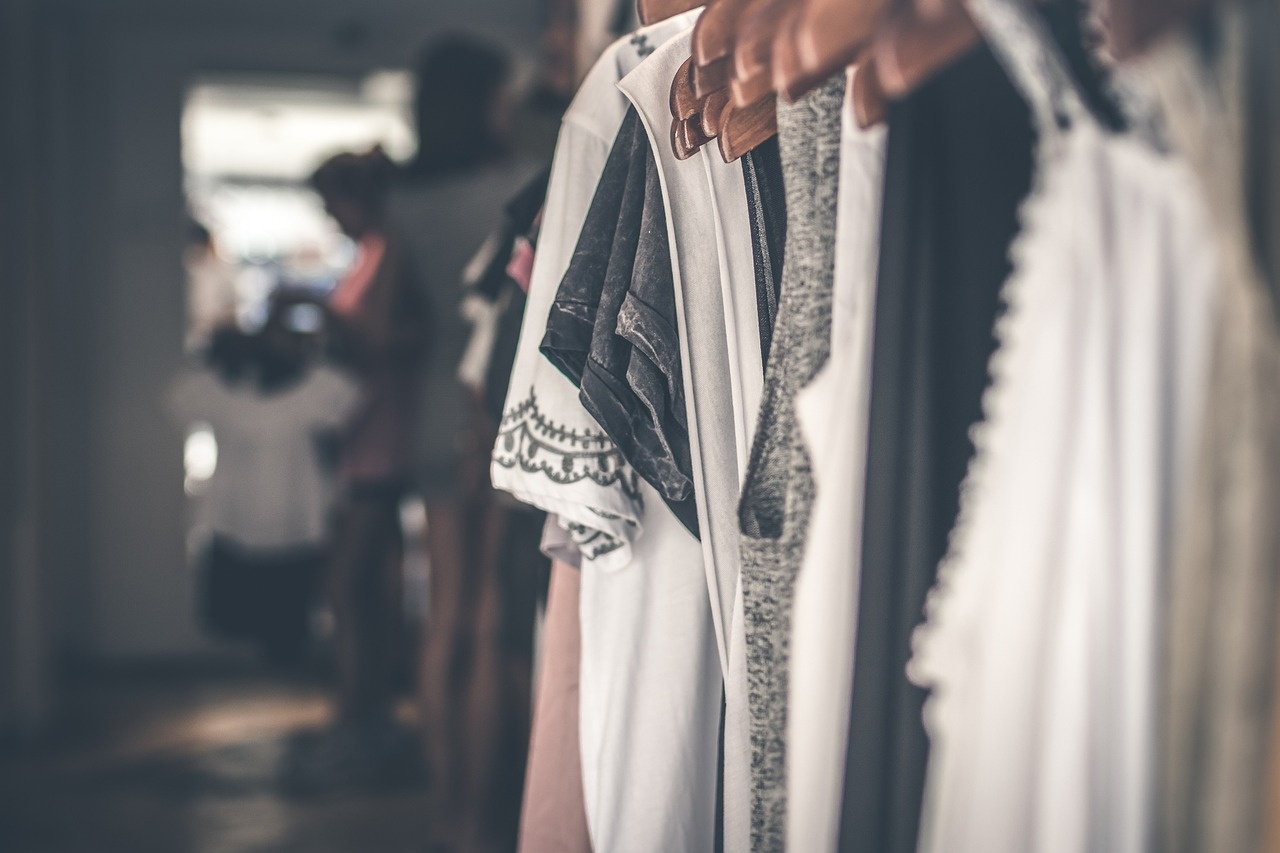 Kuratierte Garderobe auf Holzhängern im minimalistischen Showroom